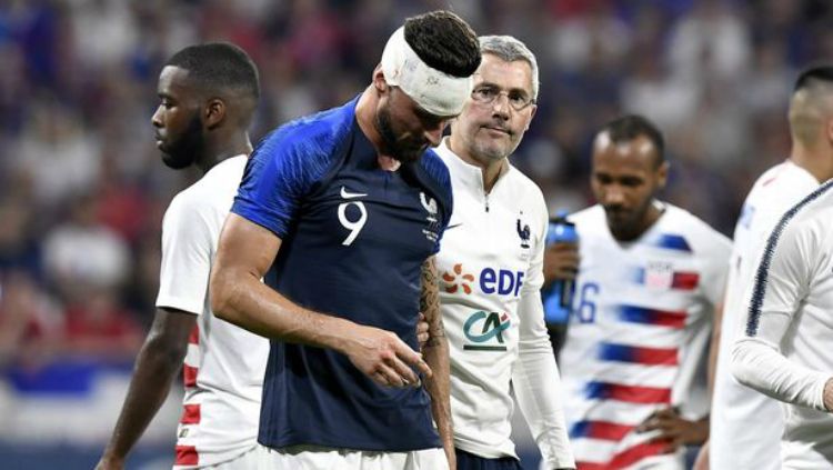 Olivier Giroud harus diperban kepalanya usai tubrukan dengan Matt Miazga dalam laga Prancis vs AS jelang Piala Dunia 2018. Copyright: © AFP