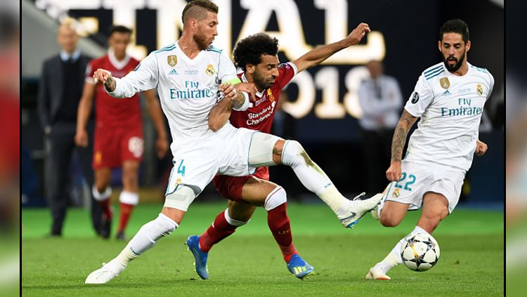 Momen saat duel antara bek tengah Real Madrid, Sergio Ramos (kiri) melawan Mohamed Salah, penyerang Liverpool dalam pertandingan final Liga Champions 2018. Copyright: © Getty Images