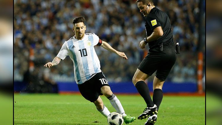 Lionel Messi saat menggiring bola dalam sebuah pertandingan bersama Timnas Argentina. Copyright: © Getty Images