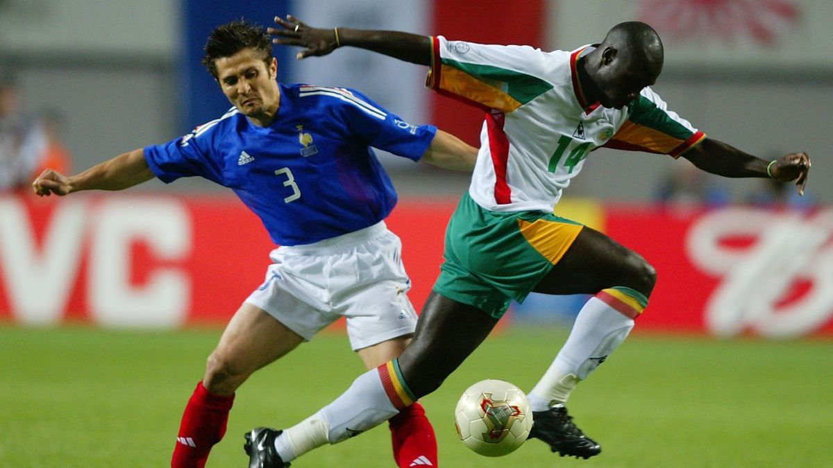 Pemain Prancis Lizaazu berebut bola dengan pemain Senegal, Papa Dioup di pertandingan Piala Dunia 2002 Copyright: © GettyImage