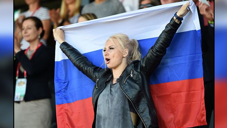 Salah satu fans wanita asal Rusia yang berada di tribun penonton. Copyright: © Getty Images