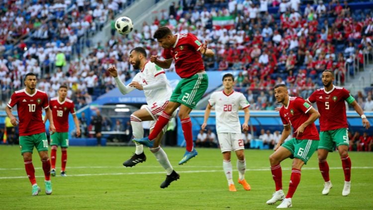 Roozbeh Cheshmi berduel di udara untuk menyundul bola dengan bek Maroko, Achraf Hakimi, di Piala Dunia 2018. Copyright: © Getty Images
