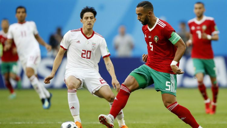 Kapten Timnas Maroko, berusaha menghalau pergerakan penggawa Timnas Iran di laga Grup B Piala Dunia 2018. Copyright: © Getty Images