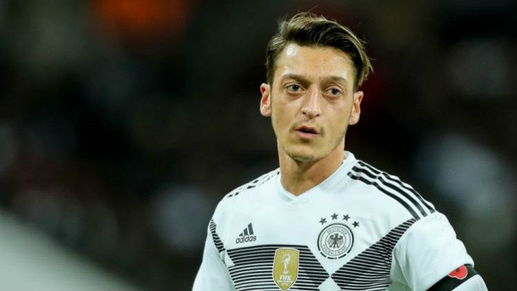 Pendukung tim tuan rumah, Qatar, kedapatan membawa foto Mesut Ozil dalam pertandingan antara Spanyol vs Jerman di Stadion Al-Bayt Al-Khor, Minggu (28/11/22). Copyright: © Getty Images