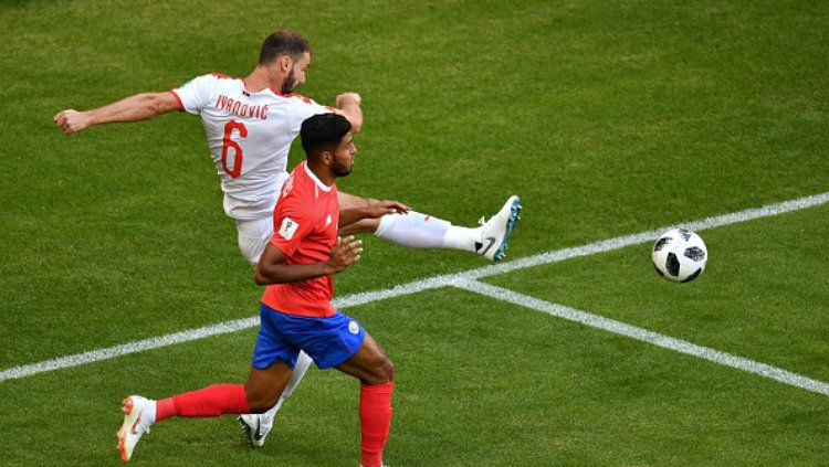 Bek Serbia, Branislav Ivanovic (putih) menghalau dan membuang bola dari Johan Venegas. Copyright: © Getty Images