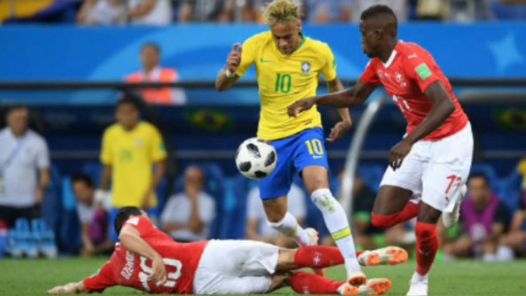 Neymar ketika berjibaku dengan dua pemain Swiss di Piala Dunia 2018. Copyright: © Getty Images