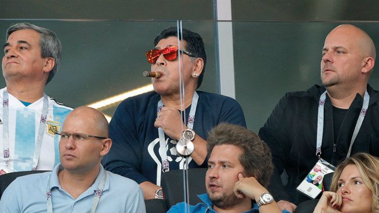 Diego Maradona yang merokok di tribune VIP laga Argentina vs Islandia di Piala Dunia 2018. Copyright: © Getty Images