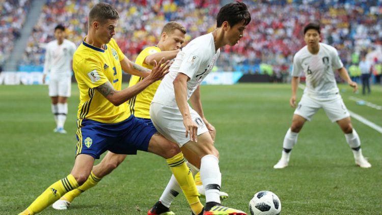 Mikael Lustig dan Koo Ja-Cheol memperebutkan bola di laga Piala Dunia 2018. Copyright: © Getty Images