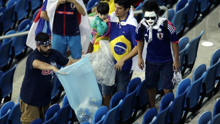 Suporter Jepang memungut sampah saat hadir di Piala Dunia 2014 di Brasil lalu. Copyright: © twitter.com/GlobalEdmonton