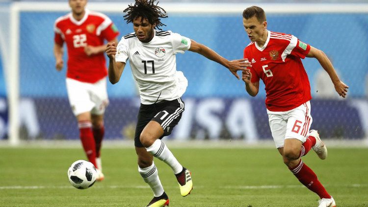 Gelandang Mesir Mohamed El Neny saat melewati pemain Rusia di Piala Dunia 2018. Copyright: © Getty Images