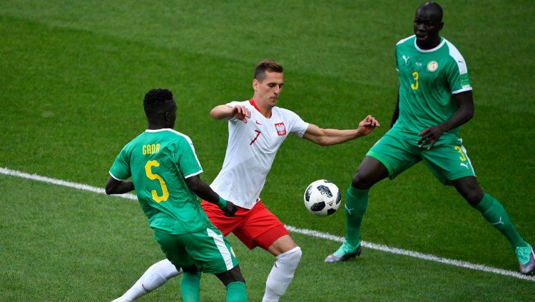 Gelandang serang Polandia Arkadiusz Milik saat berusaha melewati pemain Senegal di Piala Dunia 2018. Copyright: © Getty Images