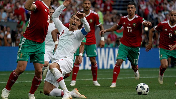 Cristiano Ronaldo saat terjatuh di dalam kotak penalti Maroko. Copyright: © Getty Images