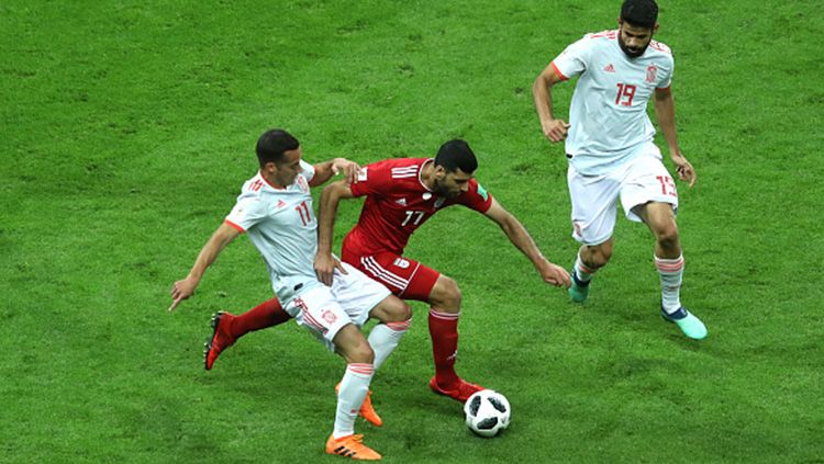 Pemain Iran dihadang oleh Diego Costa dan Lucas Vazquez. Copyright: © Getty Images