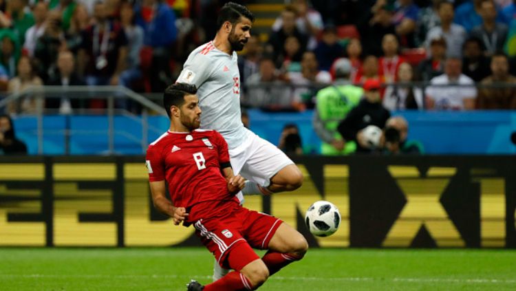 Morteza Pouraliganji beradu dengan Diego Costa dalam laga Spanyol vs Iran di Piala Dunia 2018. Copyright: © Getty Images