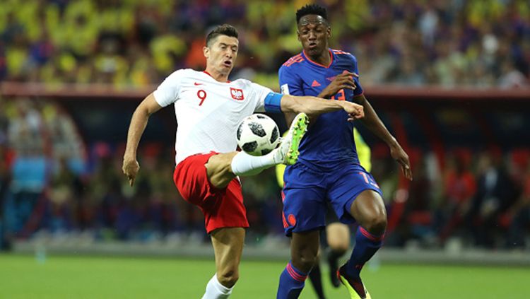 Robert Lewandowski berduel dengan pemain Kolombia, Yerry Mina. Copyright: © Getty Images