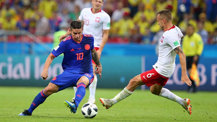 James Rodriguez tengah melewati kawalan pemain Polandia Copyright: © Getty Images