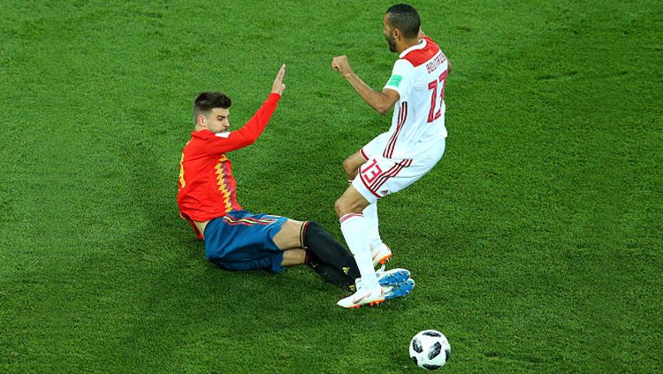 Gerard Pique (kiri) menekel dua kaki ke pemain Maroko, Khalid Boutaib. Copyright: © Getty Images