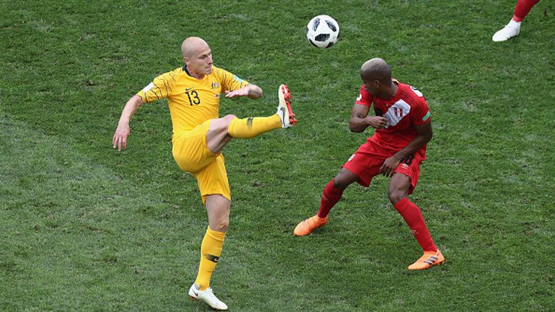 Aaron Mooy (kiri) saat berduel dengan pemain Peru. Copyright: © Getty Images