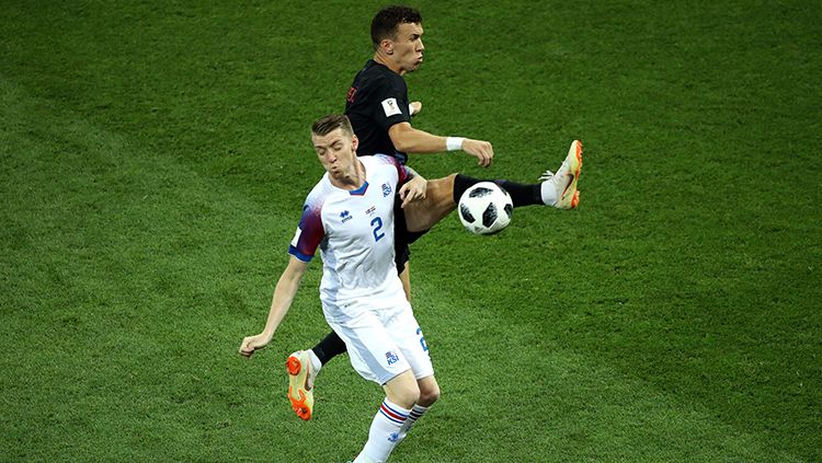Kontak fisik Birkir Saevarsson dengan Ivan Perisic dalam perebutan bola. Copyright: © Getty Images