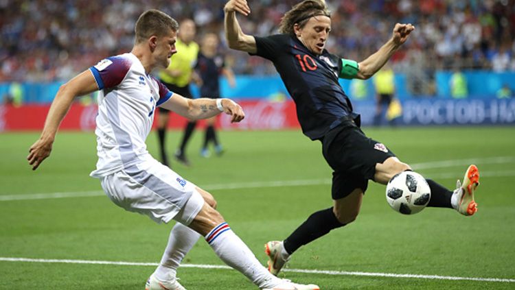 Luka Modric berusaha memblok tendangan pemain Islandia. Copyright: © Getty Images