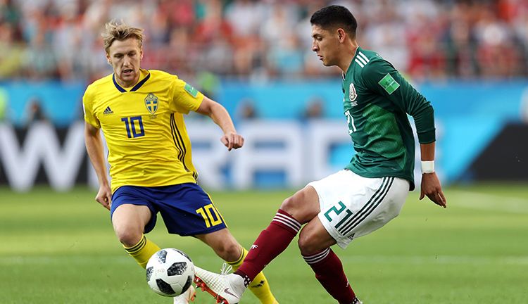 Emil Forsberg berebut bola dengan pemain Meksiko. Copyright: © Getty Images