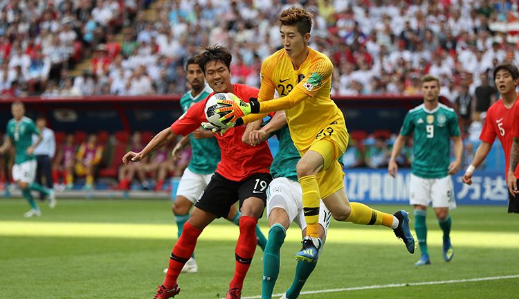 Hyeonwoo Jo berhasil mengamankan bola dari serbuan pemain Jerman. Copyright: © Getty Images