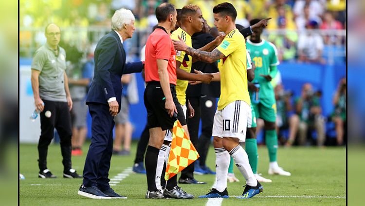 James Rodriguez (kanan) saat ditarik keluar dan digantikan oleh Luis Muriel ketika Timnas Kolombia melawan Timnas Senegal di Piala Dunia 2018. Copyright: © Getty Images