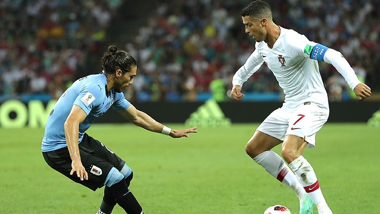 Cristiano Ronaldo mencoba melawati adangan pemain Uruguay. Copyright: © Getty Images