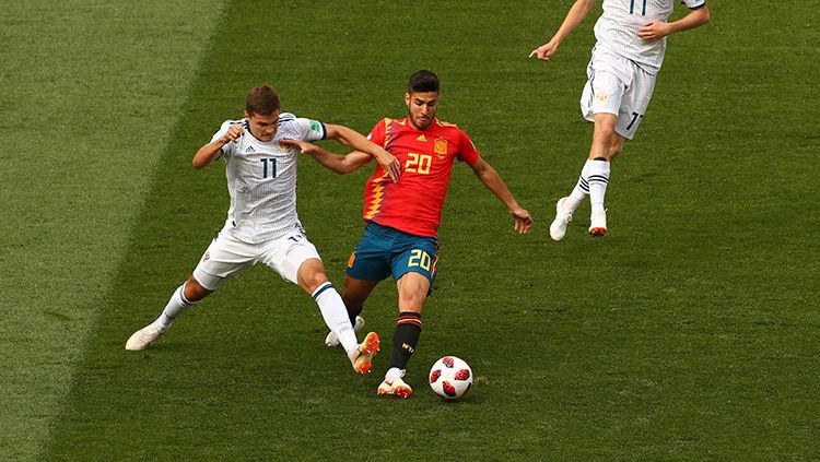 Perebutan bola di laga antara Spanyol dan Rusia di Piala Dunia 2018. Copyright: © Getty Images