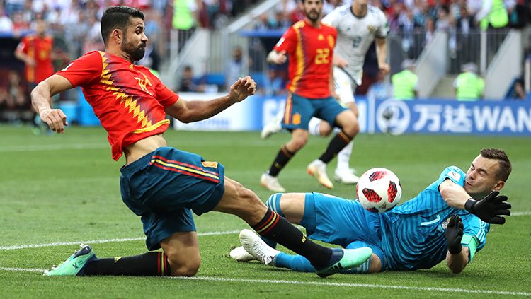 Kiper Rusia, Igor Akinfeev, menahan serangan Diego Costa. Copyright: © Getty Images