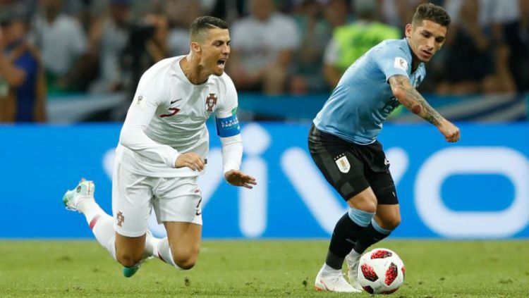 Lucas Torreira (kanan) memenangkan duel dengan Cristiano Ronaldo dalam laga Uruguay vs Portugal. Copyright: © Getty Images