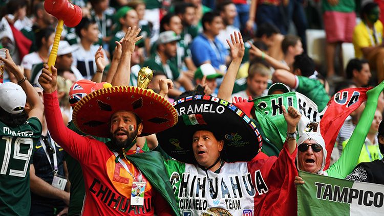 Cara unik yang dilakukan suporter Meksiko yang tengah berlaga melawan Brasil. Copyright: © Getty Images