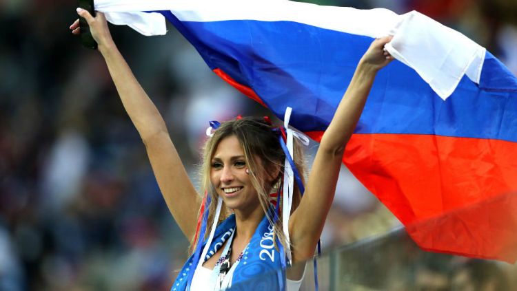 Fans Rusia tersenyum manis saat mengibarkan bendera negaranya. Copyright: © Getty Images