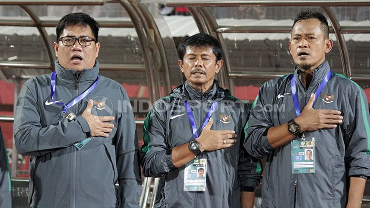 Indra Sjafri dan asisten pelatih khidmat menyanyikan Indonesia Raya. Copyright: © Fitra Herdian/INDOSPORT