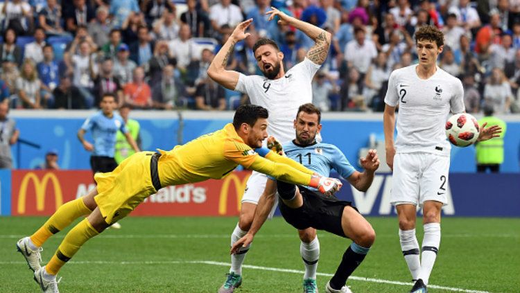 Hugo Lloris menghadang bola serangan dari pemain Uruguay di perempat final Piala Dunia 2018. Copyright: © Getty Images