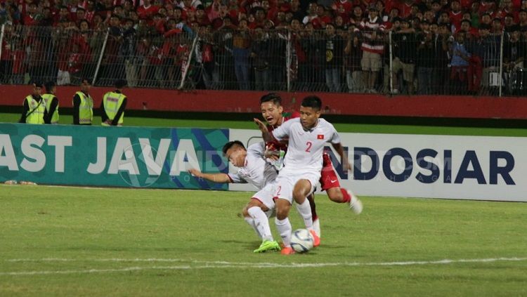 Syahrian Abimayu (belakang) dihalau oleh dua pemain Vietnam. Copyright: © Fitra Herdian/INDOSPORT