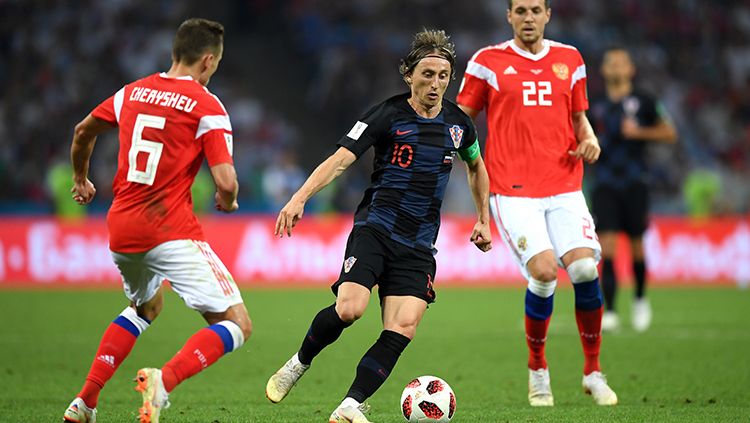 Luka Modric (tengah) mencoba melewati dua pemain Rusia. Copyright: © Getty Images