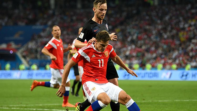 Ivan Rakitic mencoba merebut penguasaan bola dari pemain Rusia. Copyright: © Getty Images