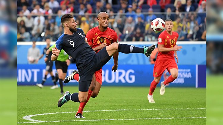 Giroud berusaha menceploskan bola ke gawang Belgia. Copyright: © INDOSPORT