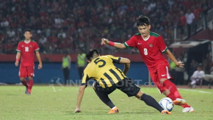 Witan Sulaiman memalingkan bola dari serangan pemain Malaysia. Copyright: © Fitra Herdian/Indosport