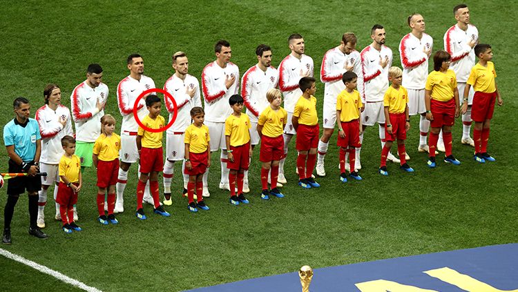 Dejan Lovren didampingi bocah asal Indonesia, Maura Alvaro Putra, saat menuju lapangan jelang laga final Piala Dunia 2018. Copyright: © Getty Images