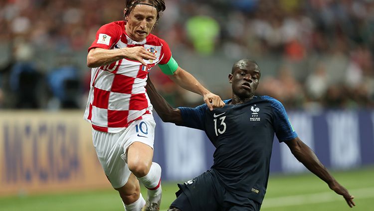N'GOlo Kante mencoba merebut penguasaan bola dari kaki Luka Modric. Copyright: © Getty Images