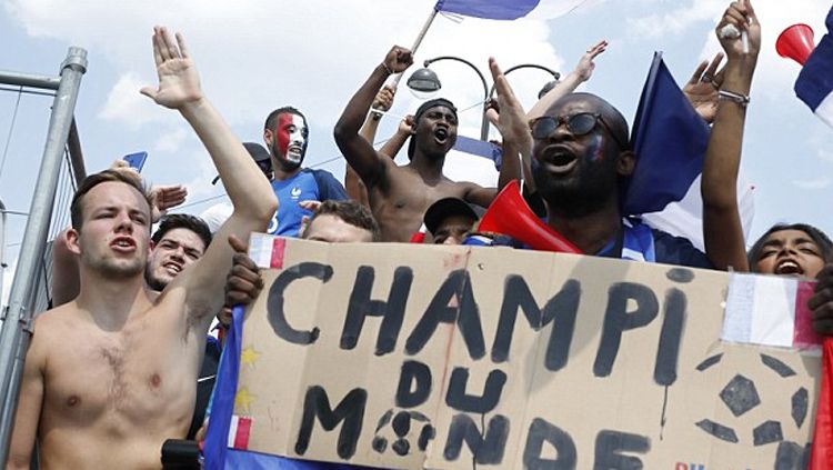 Seorang pendukung menunjukkan kepercayaan diri yang tinggi dengan meluncurkan spanduk 'Champion du Monde' yang artinya juara dunia. Copyright: © Getty Images