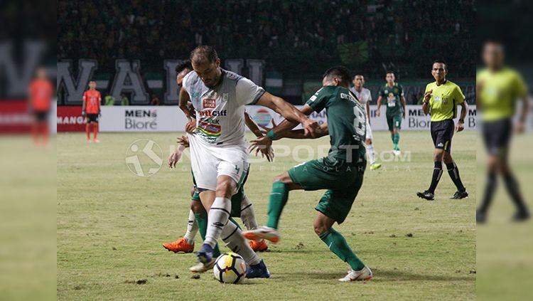 Pemain PSMS Medan berusaha menutup pergerakan pemain Persebaya pada lanjutan laga Liga 1, Rabu (18/7/18). Copyright: © INDOSPORT/Fitra Herdian