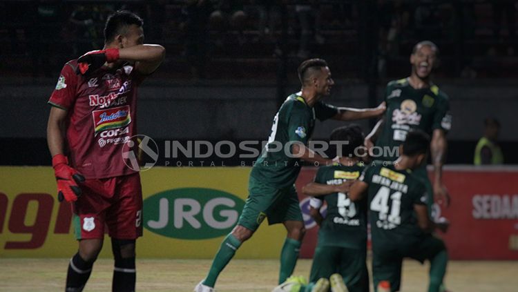 Ekspresi kiper PSMS Medan Abdul Rohim saat gawangnya berhasil dibobol oleh pemain Persebaya pada lanjutan laga Liga 1 2018. Copyright: © INDOSPORT/Fitra Herdian