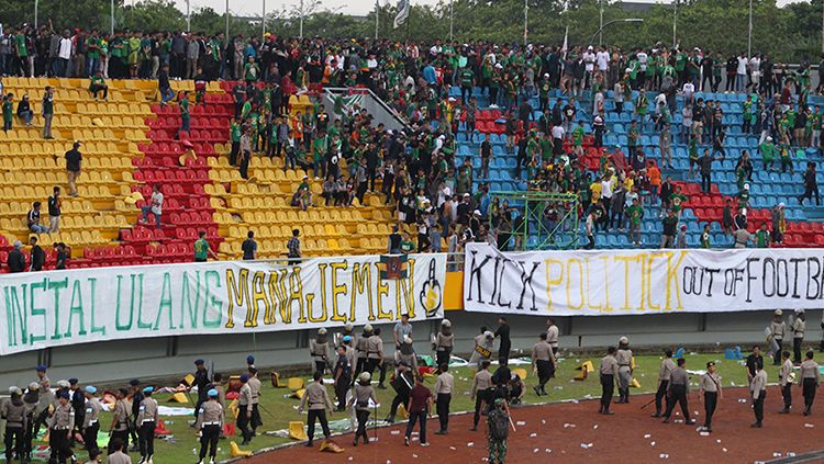 Amukan oknum suporter yang kecewa dengan hasil laga Sriwijaya vs Arema mengakibatkan kursi-kursi stadion tercabut dari tribun. Copyright: © Bolabanget