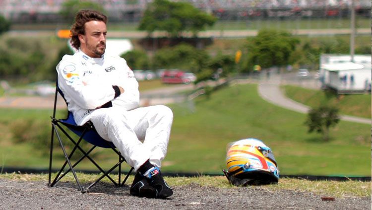 Fernando Alonso, pembalap F1 sedang duduk santai di pinggir Sirkuit Yas Marina, Abu Dhabi. Copyright: © AutoSport