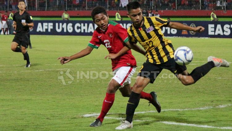 Muhammad Fajar menghalau pemain Malaysia untuk mengambil bola. Copyright: © Fitra Herdian/Indosport