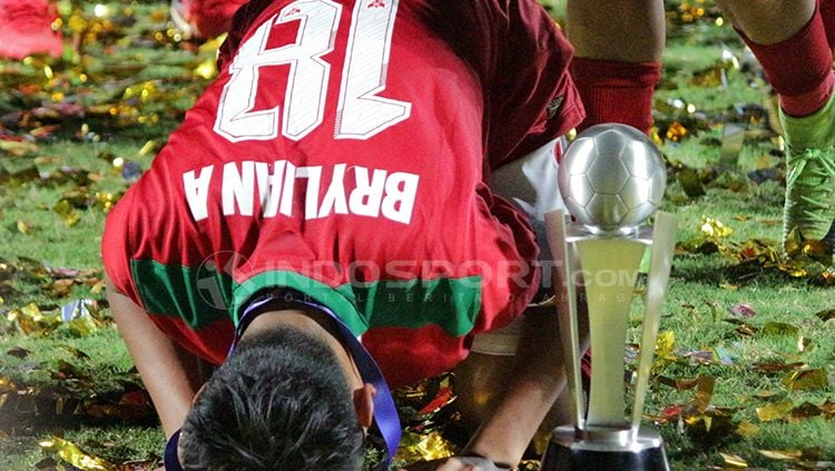 Sujud syukur Brylian bersama dengan Piala AFF U-16 2018 di sampingnya. Copyright: © Fitra Herdian/INDOSPORT