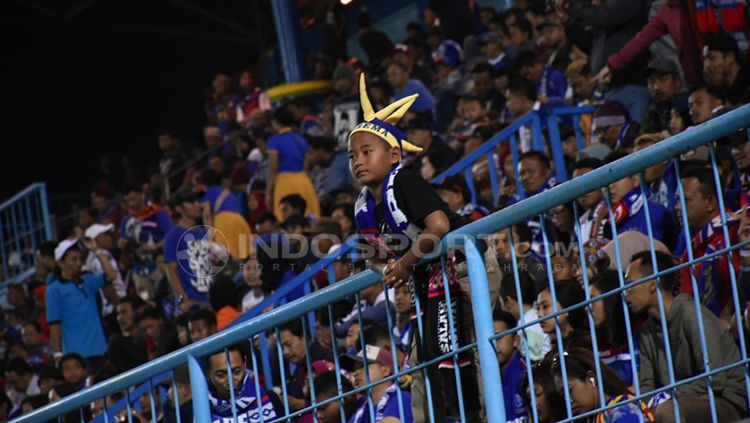 Aremania kecil tetap semangat mendukung Arema FC. Copyright: © Ian Setiawan/INDOSPORT
